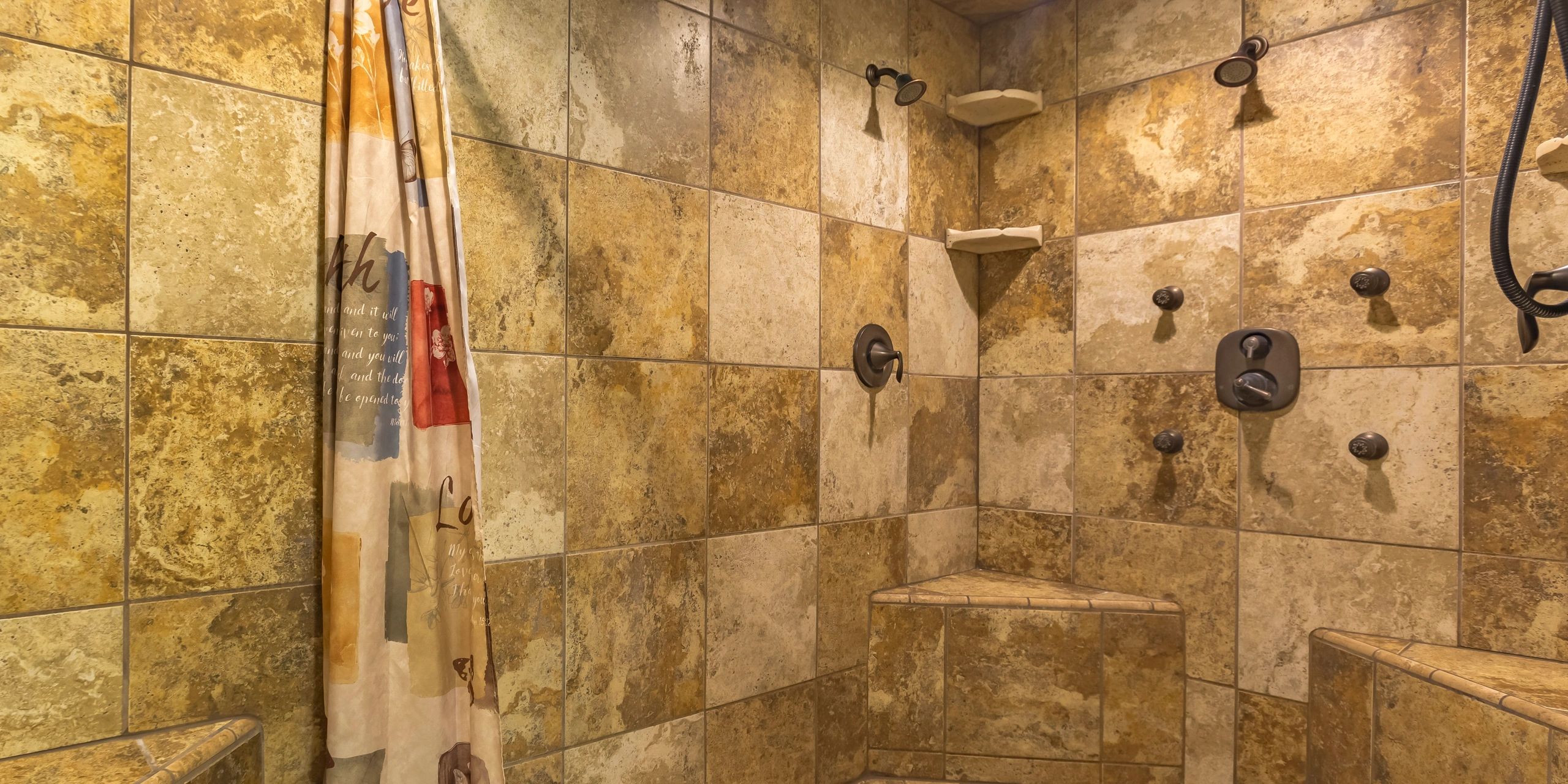 Walk-in shower with brown tile wall and dual shower heads