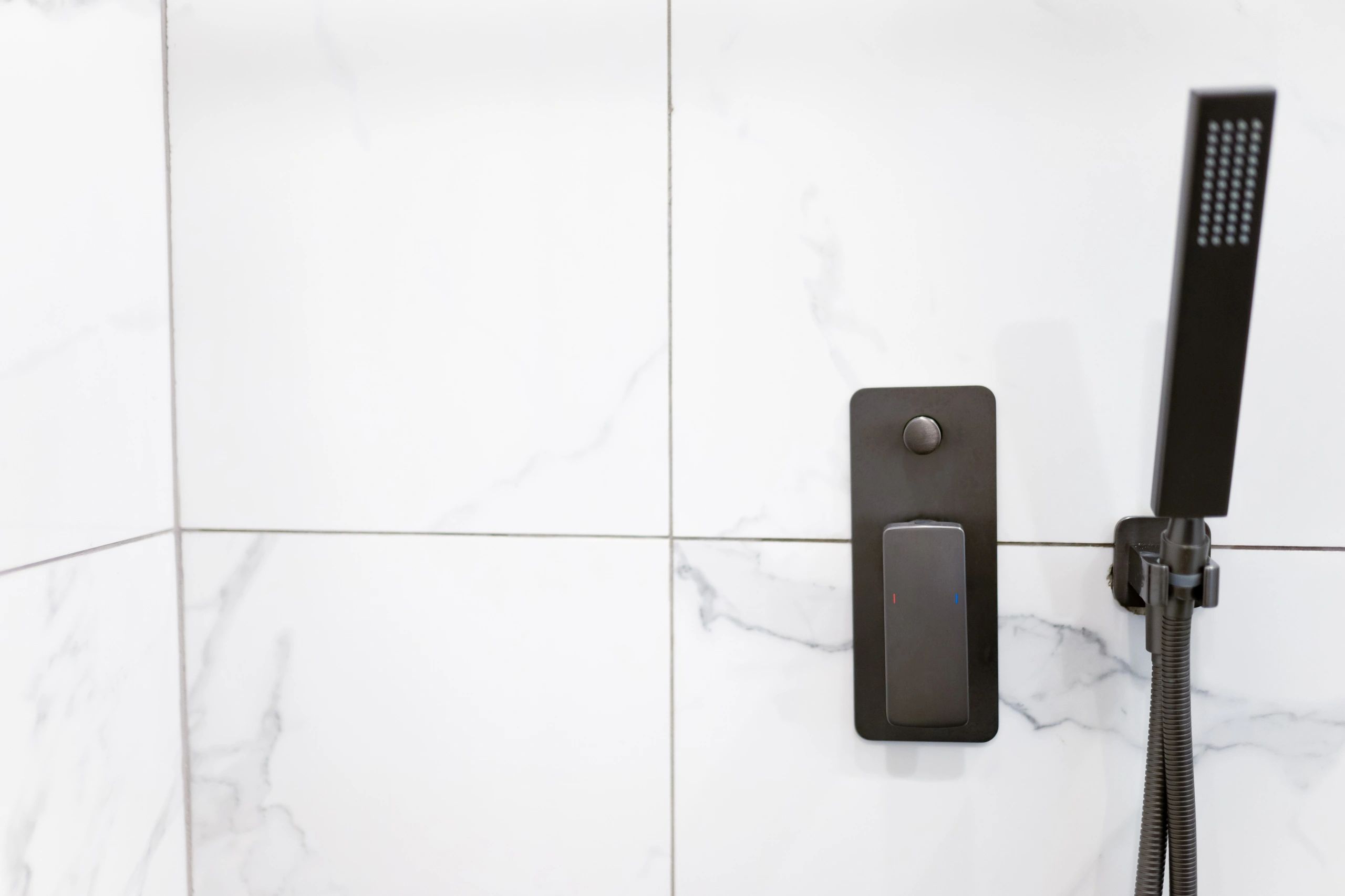 White marble walk-in shower detail with glass panel