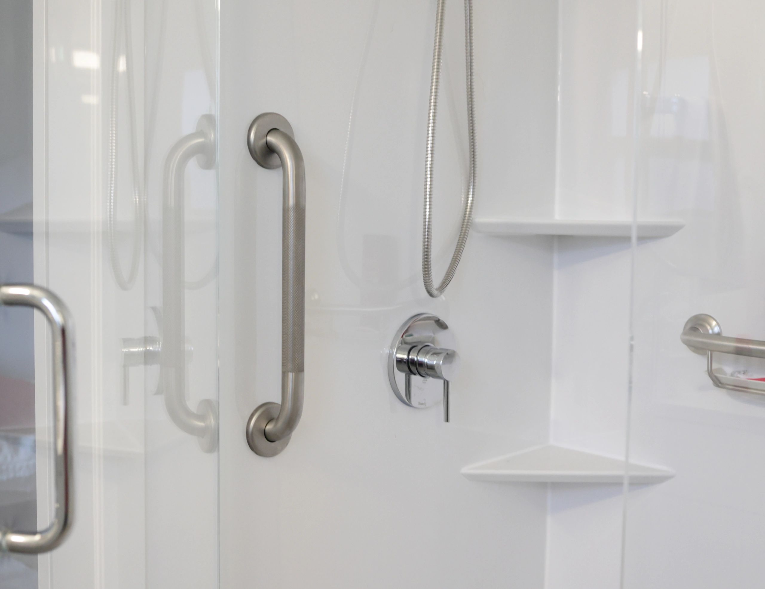 Upgraded shower stall with safety grab bar and built-in shelves